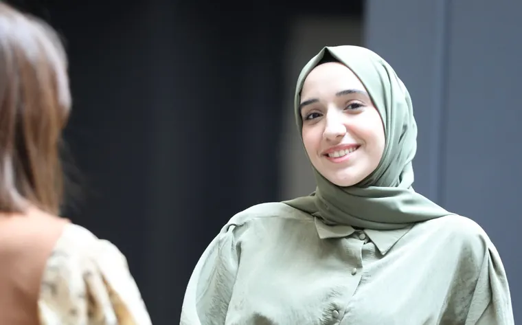 متدربة مبتسمة تتحدث مع مدرّبتها خلال اختبار المحادثة